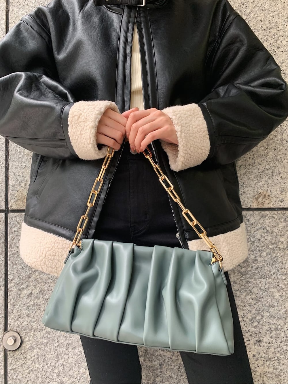 ブラック系のデニムパンツ、ブラック系のブルゾン、その他のブーツを着用したレディースの冬コーディネートの6枚目の写真