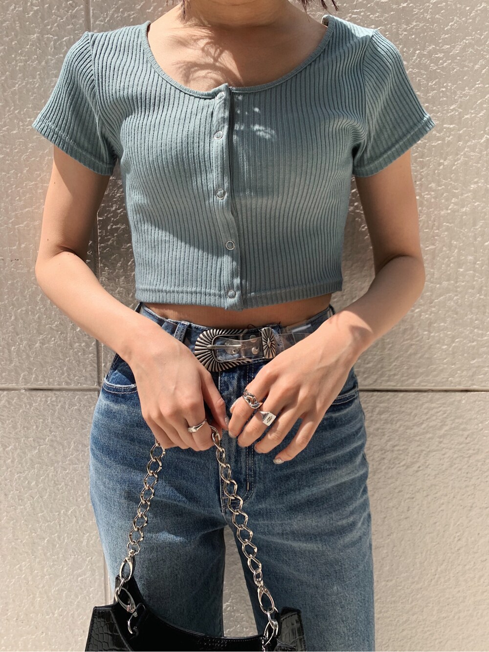 ブラック系のサンダル、ブルー系のデニムパンツ、その他のベルトを着用したレディースの春コーディネートの4枚目の写真