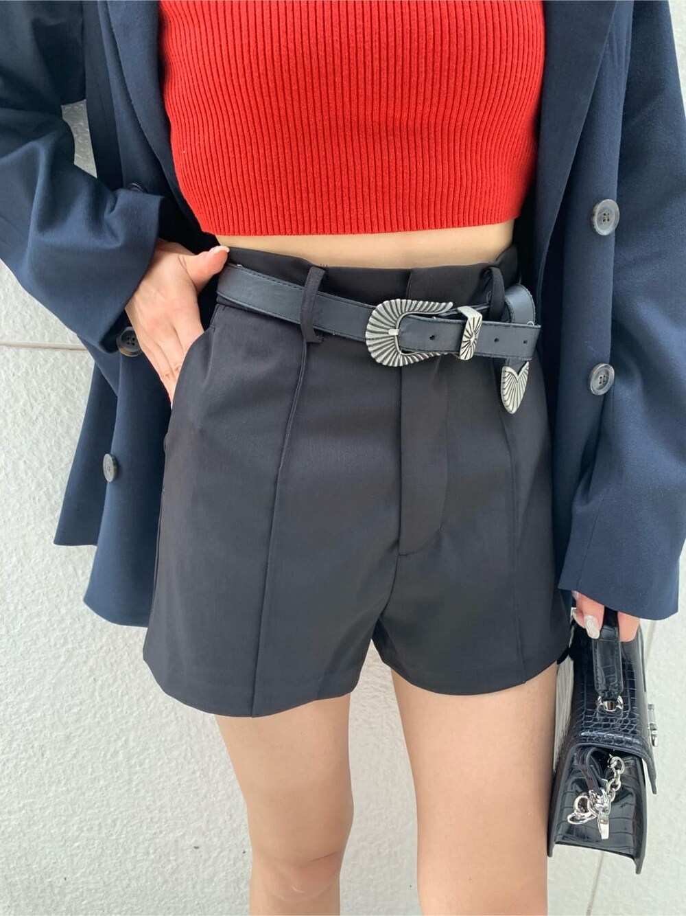 ブルー系のテーラードジャケット、ブラック系のハンドバッグ、ブラック系のブーツを着用したレディースの秋コーディネートの8枚目の写真