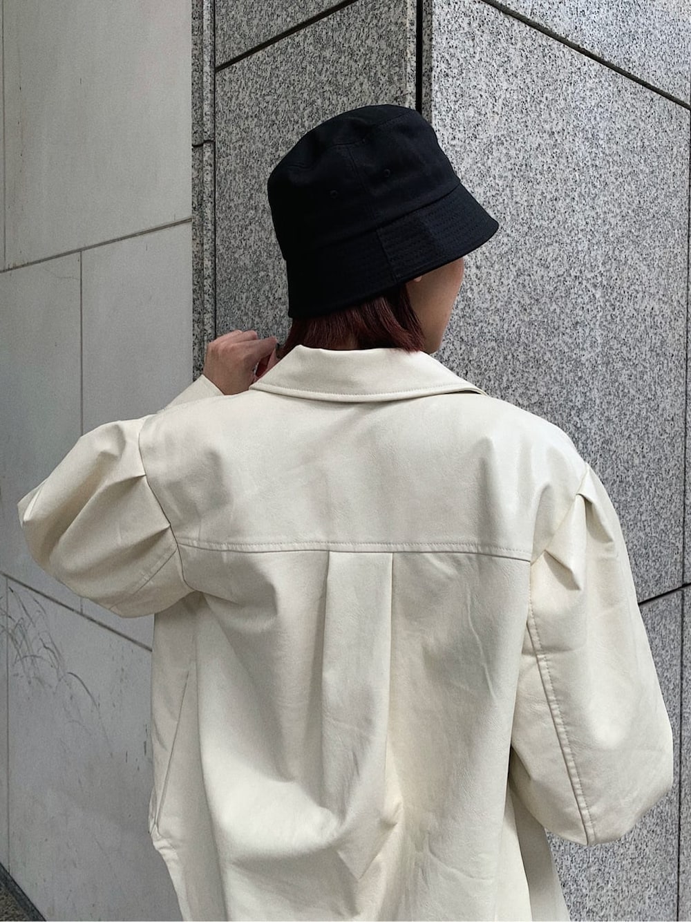 ホワイト系のテーラードジャケット、ブラック系のブーツ、ブラック系のショルダーバッグを着用したレディースの秋コーディネートの4枚目の写真