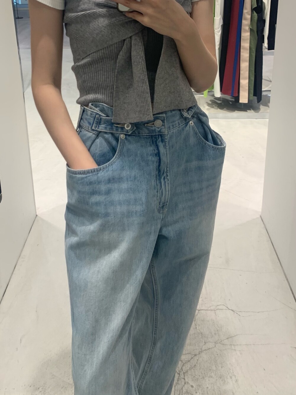 ブルー系のデニムパンツ、ブラック系のブーツ、グレー系のチューブトップを着用したレディースの春コーディネートの6枚目の写真