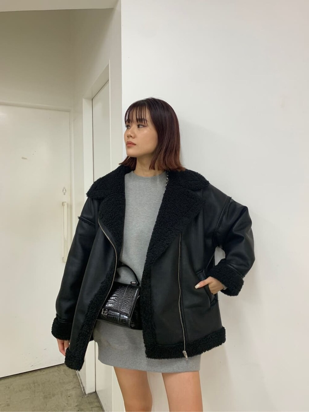 ブラック系のブーツ、グレー系のスウェット、ブラック系のブルゾンを着用したレディースの秋コーディネートの9枚目の写真