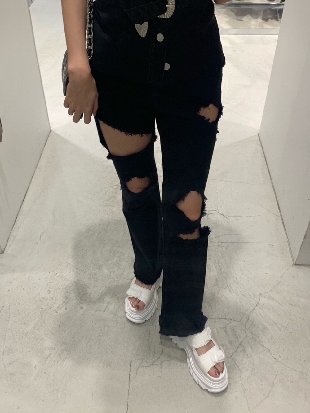 ブラック系のチューブトップ、ブラック系のデニムパンツ、ブラック系のショルダーバッグを着用したレディースの夏コーディネートの5枚目の写真