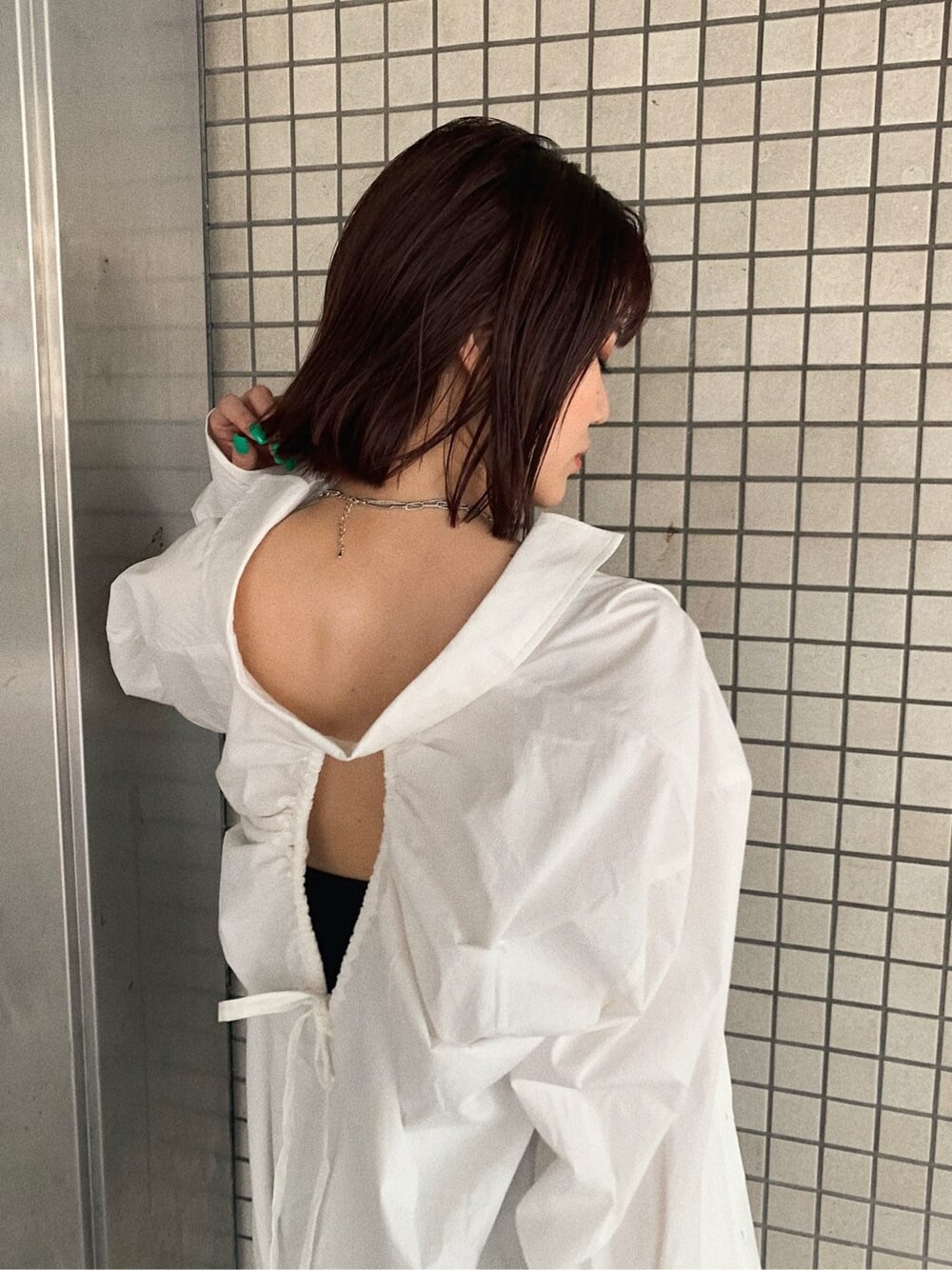 ブラック系のブーツ、ブラック系のスカート、ホワイト系のシャツ/ブラウスを着用したレディースの夏コーディネートの4枚目の写真