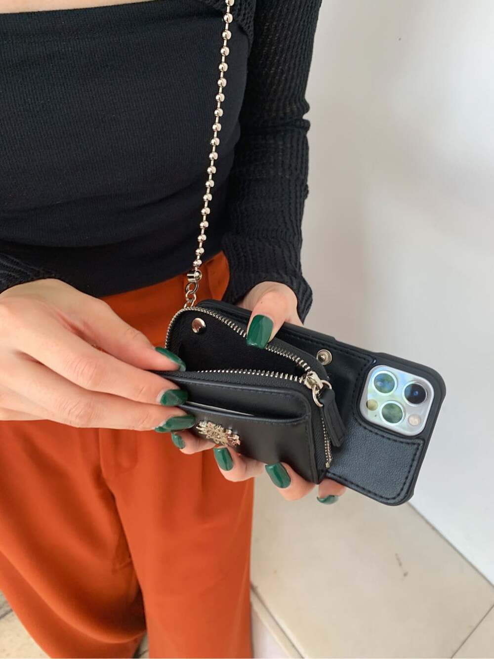 オレンジ系のその他パンツ、ブラック系のローファー、ブラック系のスマホケース/カバーを着用したレディースの秋コーディネートの6枚目の写真