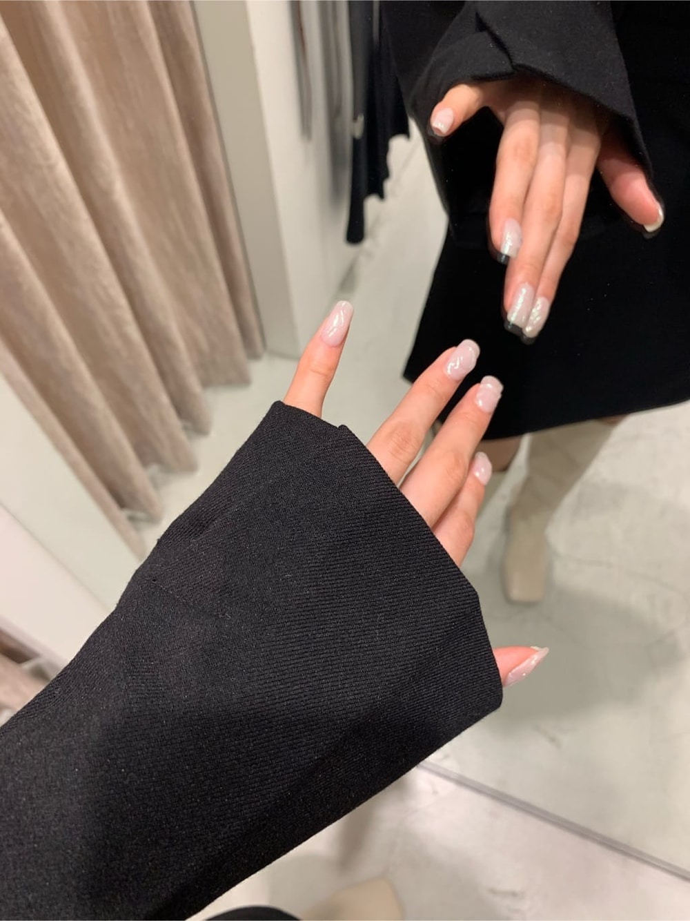 ブラック系のテーラードジャケット、ブラック系のスカート、ホワイト系のブーツを着用したレディースの秋コーディネートの6枚目の写真