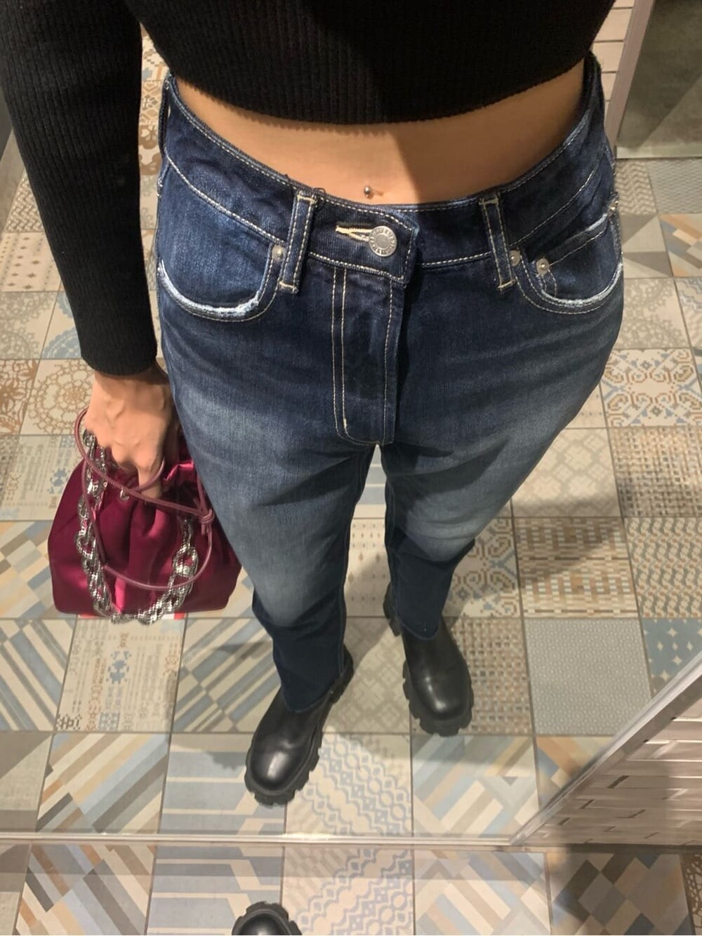 ブラック系のニット/セーター、ピンク系のハンドバッグ、ブルー系のデニムパンツを着用したレディースの秋コーディネートの5枚目の写真