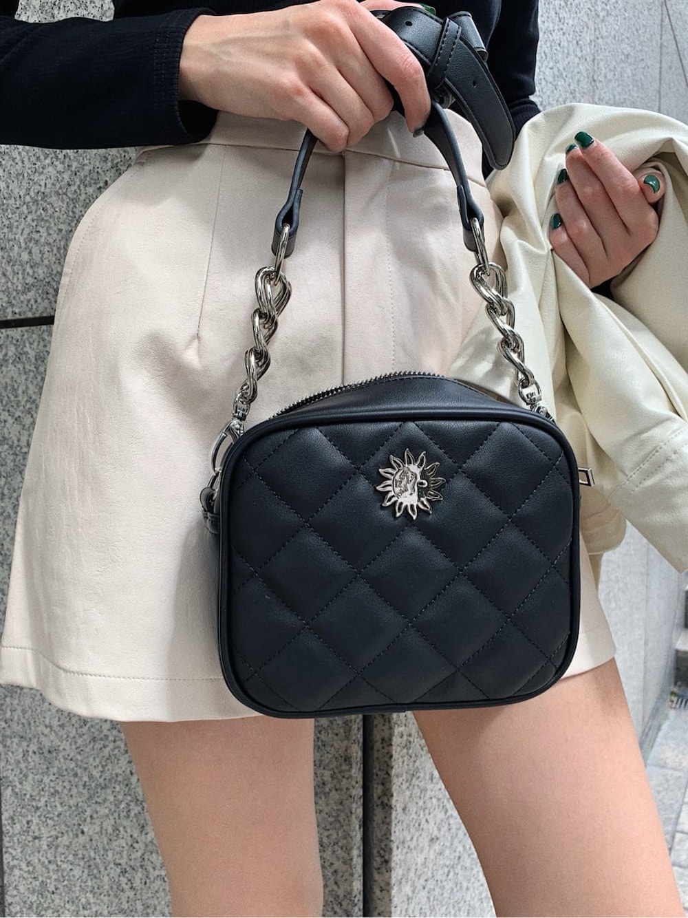 ホワイト系のテーラードジャケット、ブラック系のブーツ、ブラック系のショルダーバッグを着用したレディースの秋コーディネートの7枚目の写真