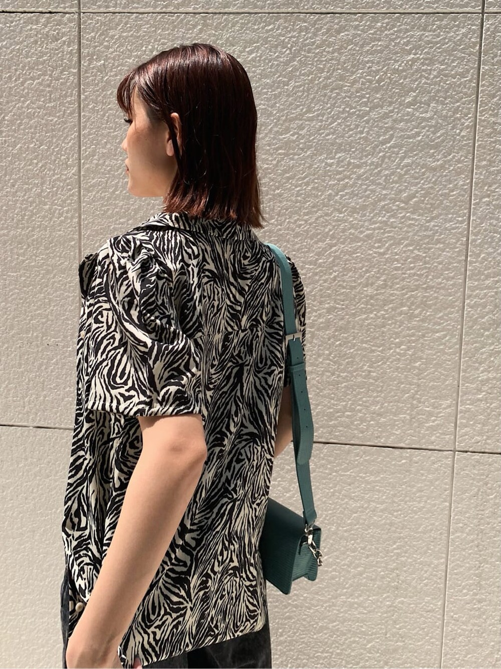 ブラック系のブーツ、ブラック系のデニムパンツ、ホワイト系のシャツ/ブラウスを着用したレディースの夏コーディネートの6枚目の写真