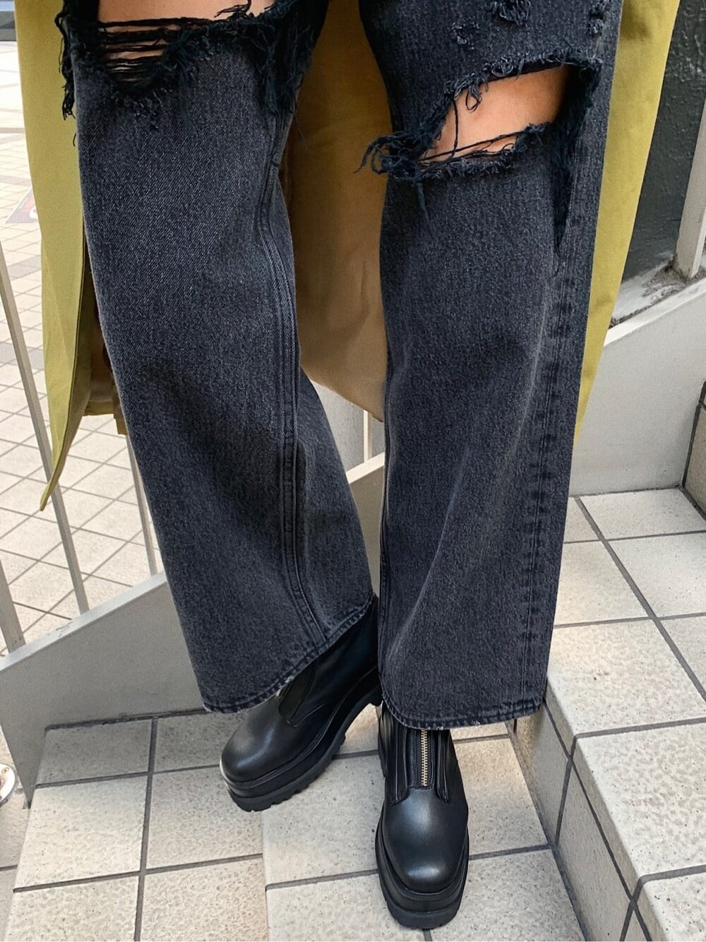 ブラック系のブーツ、ブラック系のデニムパンツ、ベージュ系のボストンバッグを着用したレディースの春コーディネートの8枚目の写真