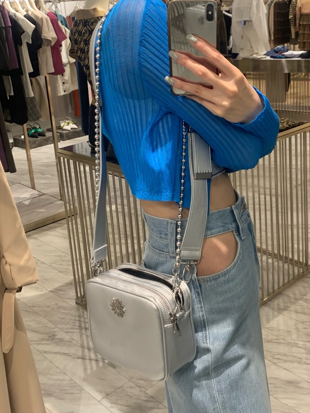 ブルー系のデニムパンツ、シルバー系のショルダーバッグ、ブルー系のカーディガン/ボレロを着用したレディースの春コーディネートの5枚目の写真