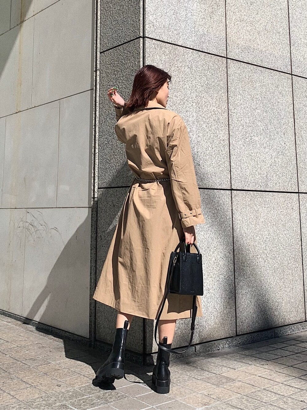 ベージュ系のスカート、ブラック系のブーツ、ブラック系のニット/セーターを着用したレディースの冬コーディネートの2枚目の写真