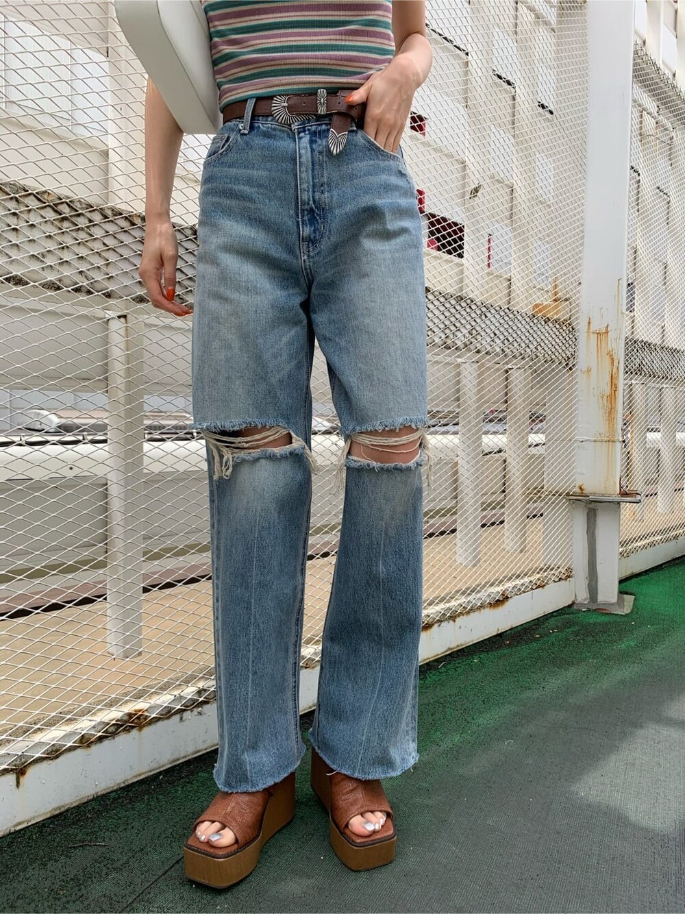 ブラウン系のサンダル、ブルー系のデニムパンツ、ホワイト系のショルダーバッグを着用したレディースの夏コーディネートの6枚目の写真