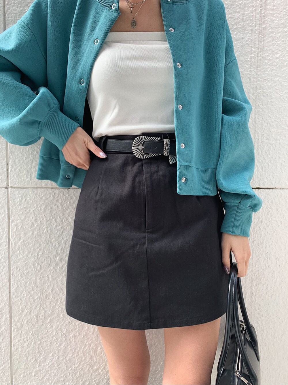 ブラック系のブーツ、ブラック系のスカート、ホワイト系のキャミソールを着用したレディースの冬コーディネートの5枚目の写真