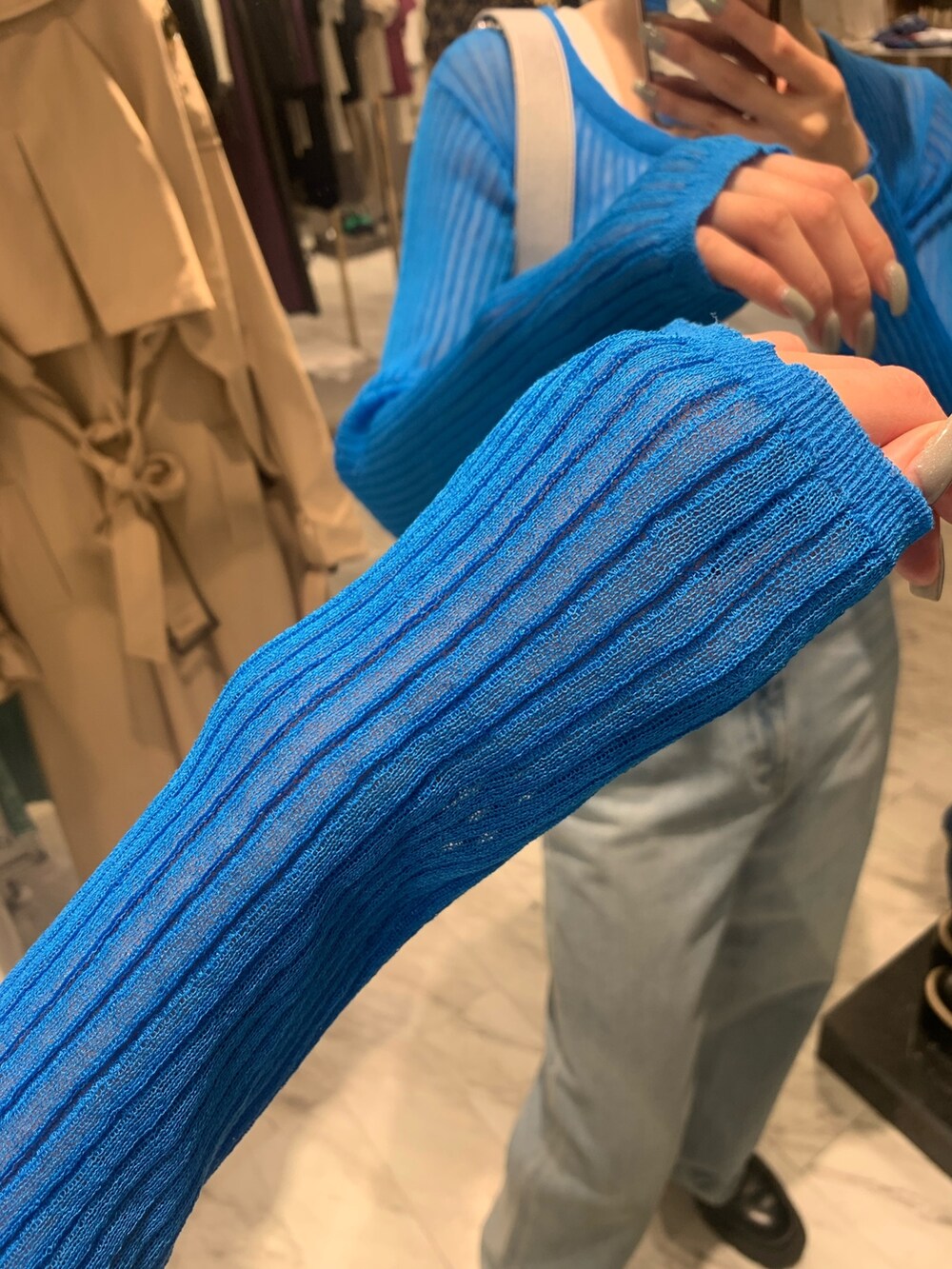 ブルー系のデニムパンツ、シルバー系のショルダーバッグ、ブルー系のカーディガン/ボレロを着用したレディースの春コーディネートの4枚目の写真