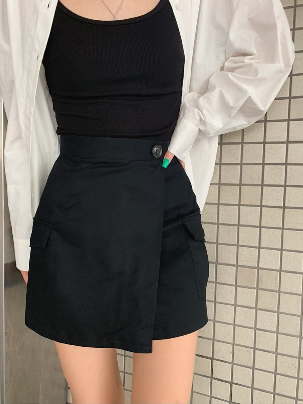 ブラック系のブーツ、ブラック系のスカート、ホワイト系のシャツ/ブラウスを着用したレディースの夏コーディネートの6枚目の写真