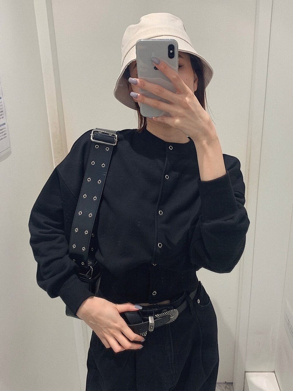 ブラック系のショルダーバッグ、ブラック系のカーディガン/ボレロ、ブラック系のブーツを着用したレディースの春コーディネートの3枚目の写真