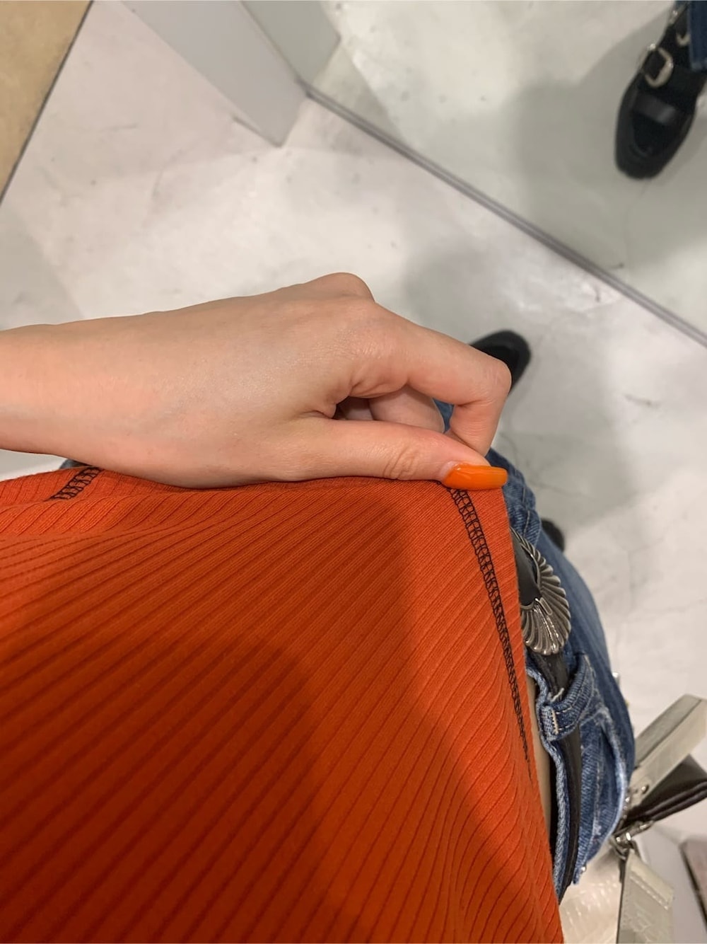 ホワイト系のショルダーバッグ、オレンジ系のTシャツ/カットソー、ブラック系のサンダルを着用したレディースの夏コーディネートの4枚目の写真