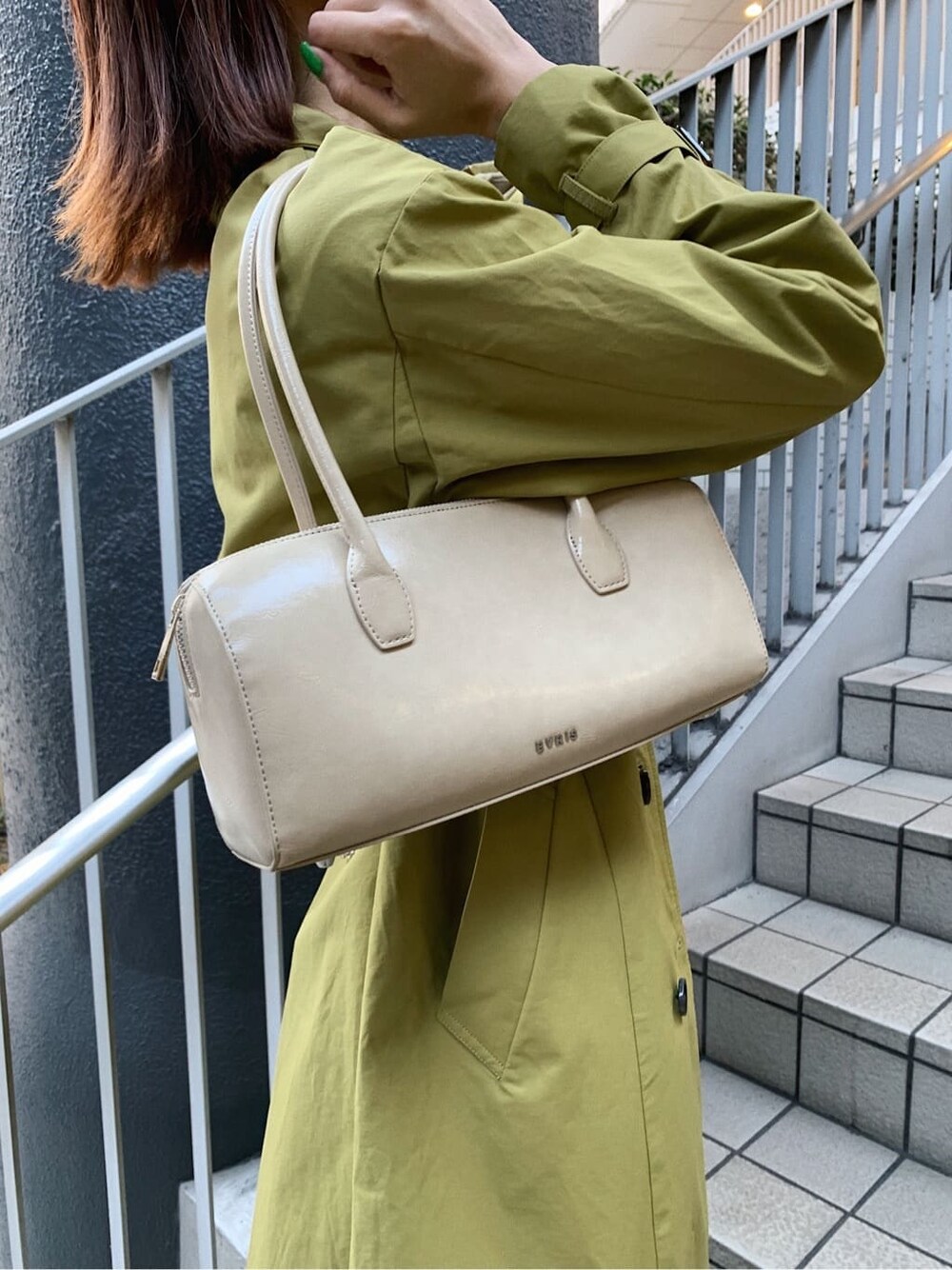 ブラック系のブーツ、ブラック系のデニムパンツ、ベージュ系のボストンバッグを着用したレディースの春コーディネートの7枚目の写真