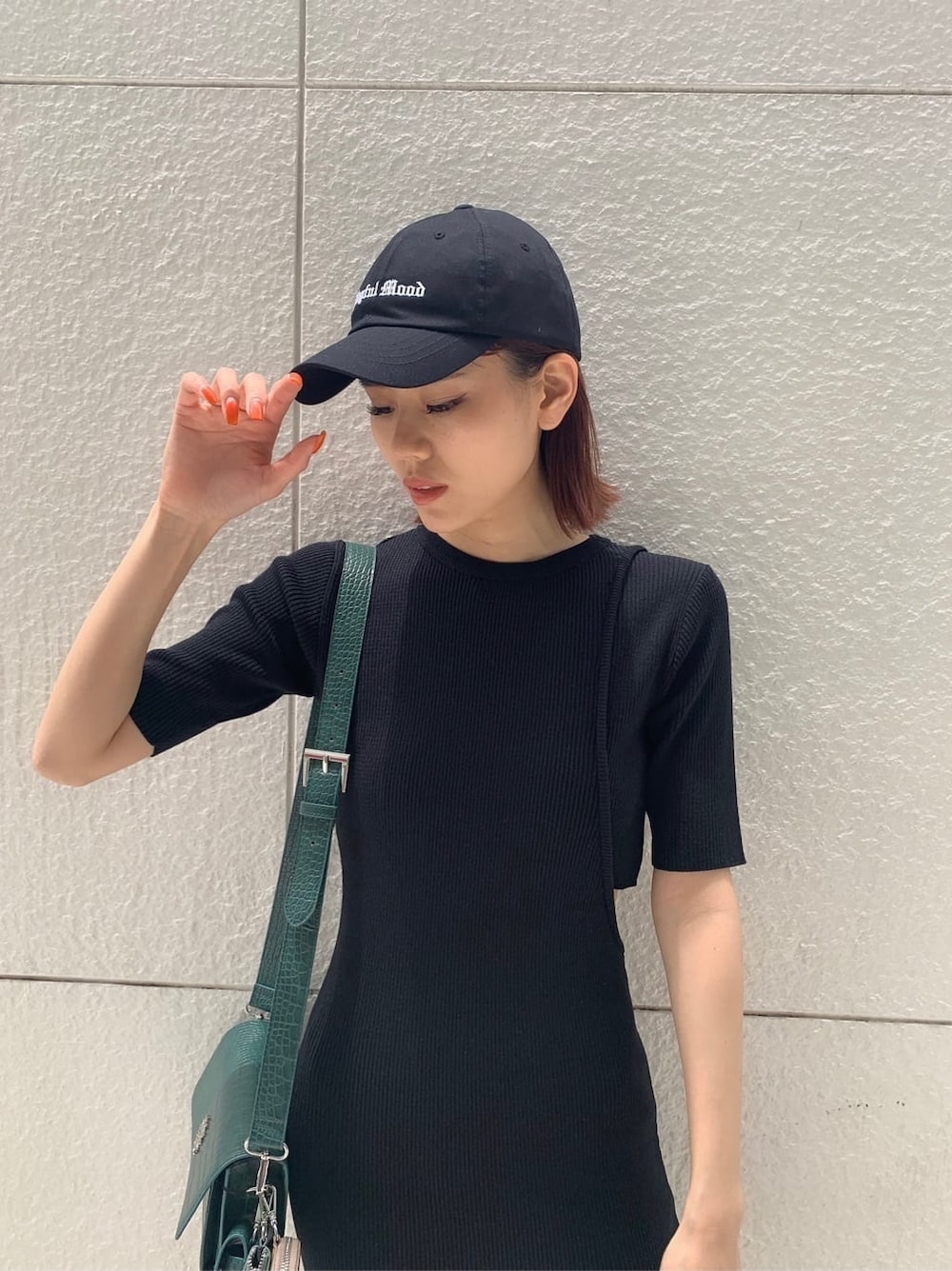 ブラック系のワンピース、ブラック系のブーツ、グリーン系のショルダーバッグを着用したレディースの夏コーディネートの3枚目の写真