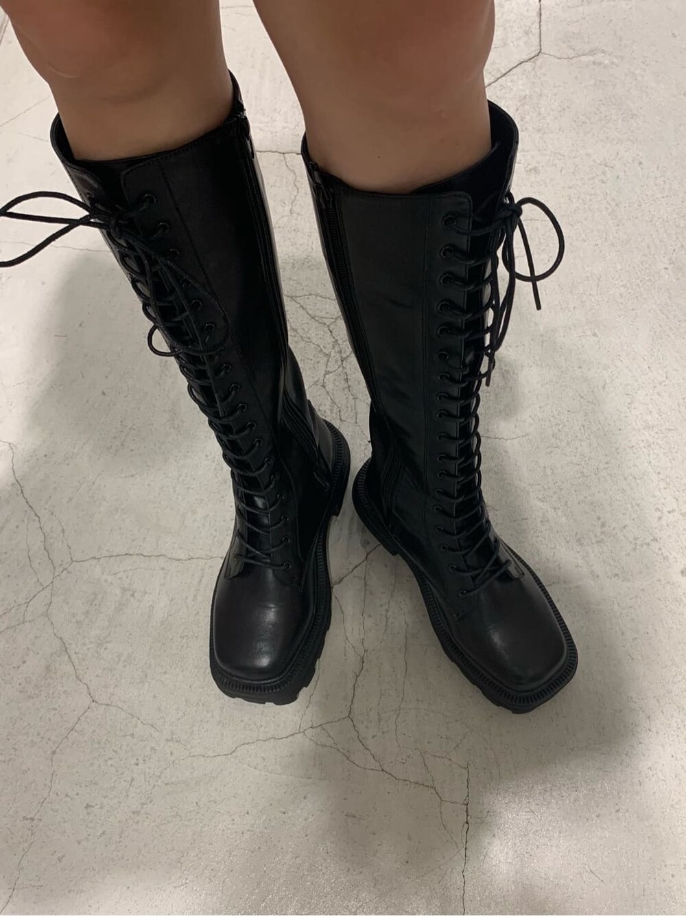 ブラック系のワンピース、ブラック系のブーツ、ブルー系のショルダーバッグを着用したレディースの夏コーディネートの7枚目の写真