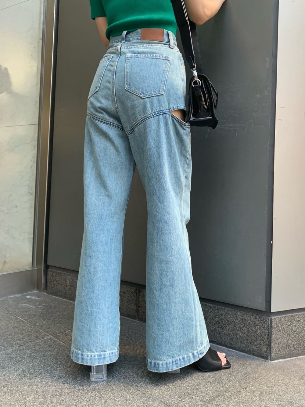 ブルー系のデニムパンツ、ブラック系のサンダル、ブラック系のショルダーバッグを着用したレディースの夏コーディネートの6枚目の写真