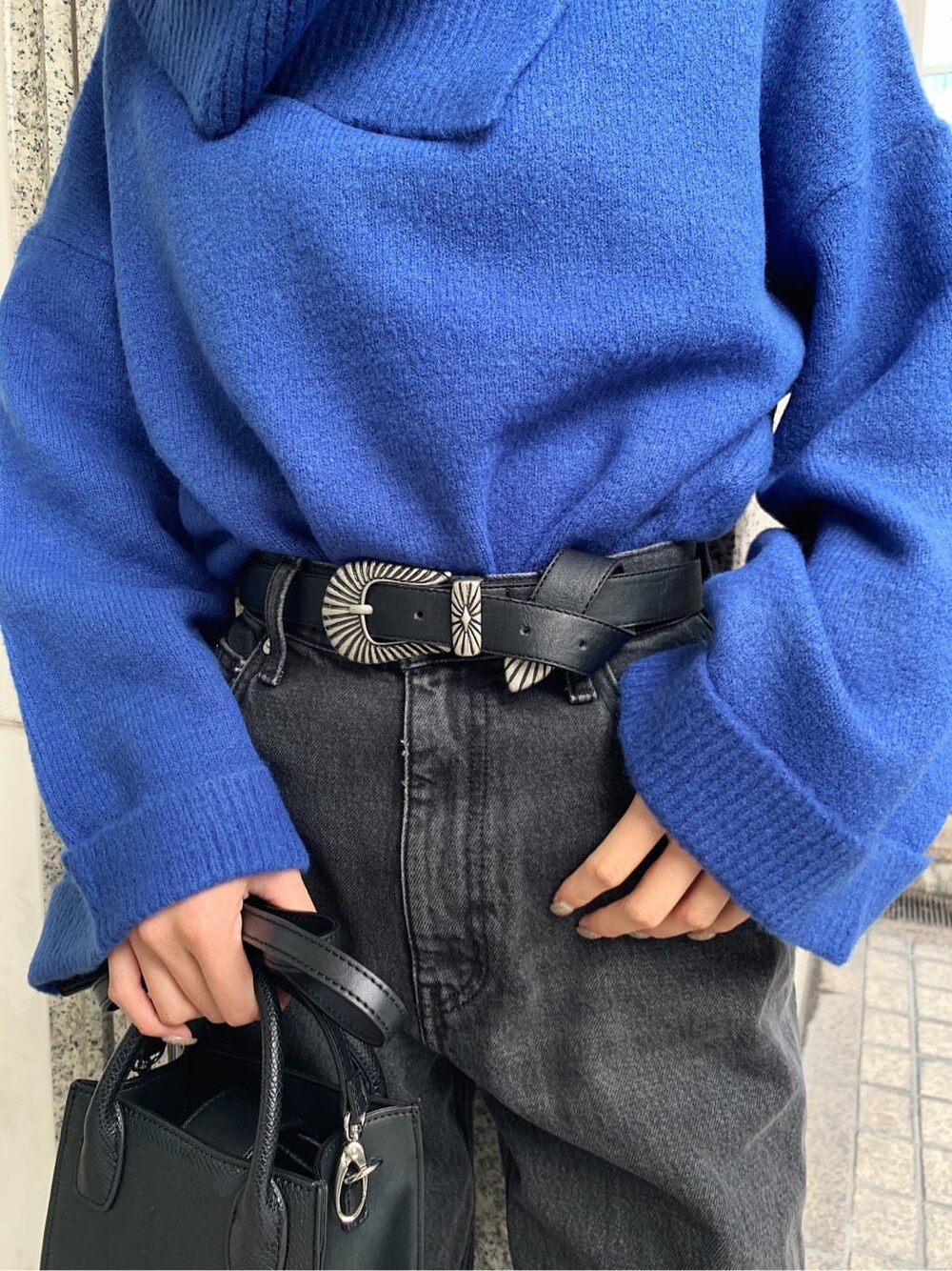 ブラック系のデニムパンツ、ブラック系のブーツ、ブラック系のショルダーバッグを着用したレディースの冬コーディネートの4枚目の写真