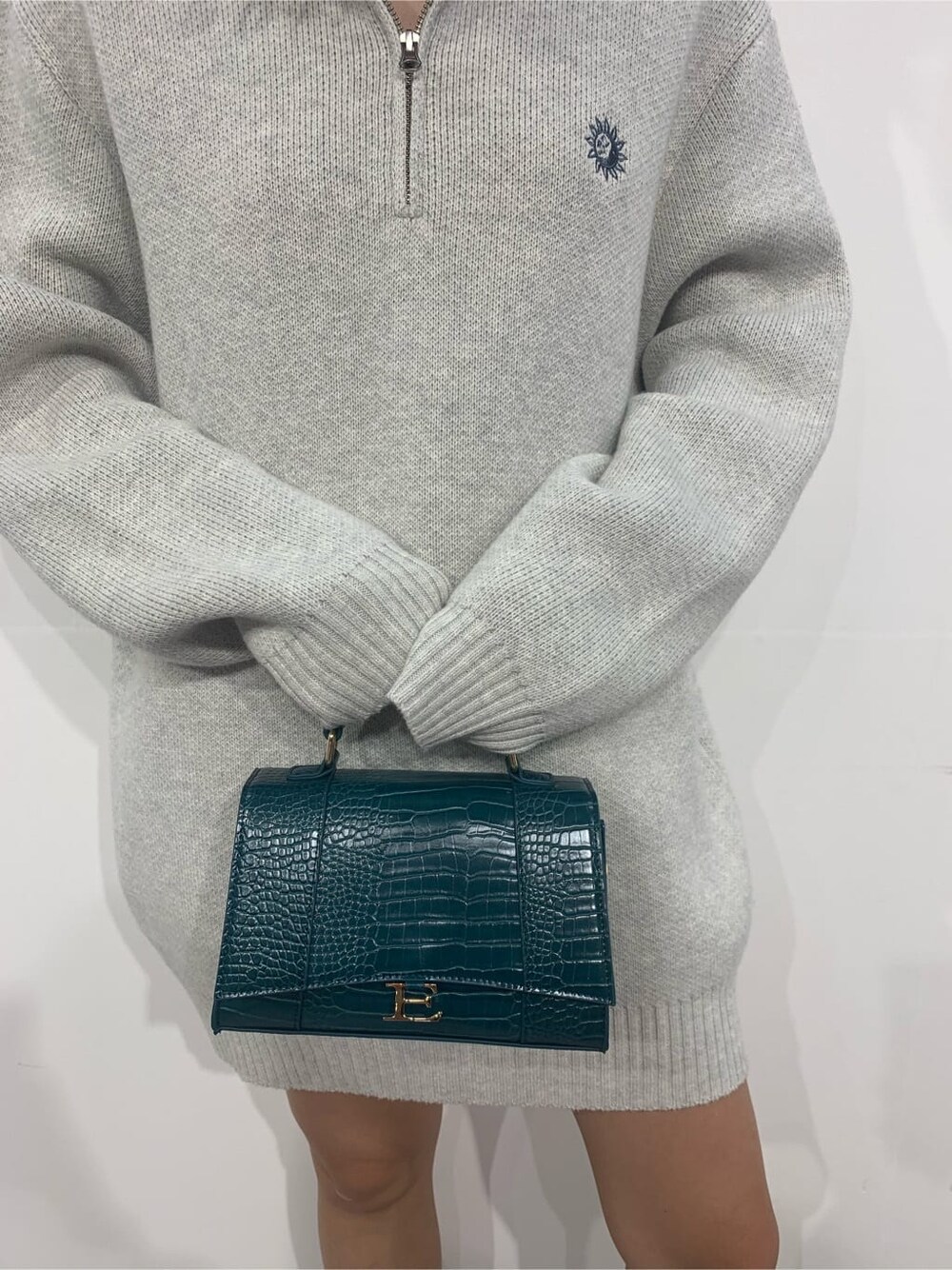 グレー系のニット/セーター、ブラック系のブーツ、グリーン系のショルダーバッグを着用したレディースの秋コーディネートの7枚目の写真