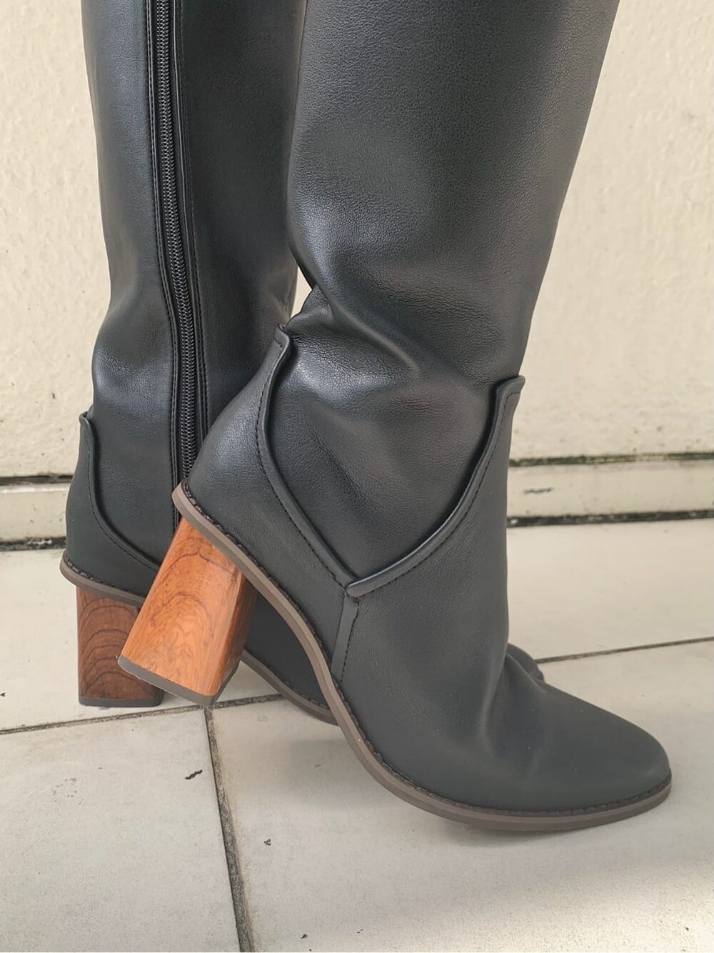 ブラック系のデニムパンツ、ブラック系のショルダーバッグ、ブラック系のブーツを着用したレディースの秋コーディネートの9枚目の写真