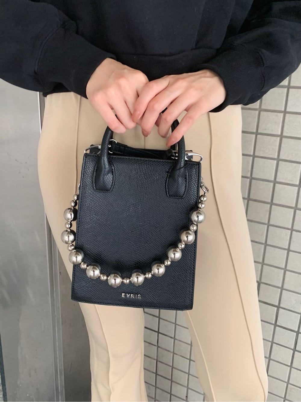 ブラック系のブーツ、ホワイト系のその他パンツ、ブラック系のショルダーバッグを着用したレディースの秋コーディネートの5枚目の写真