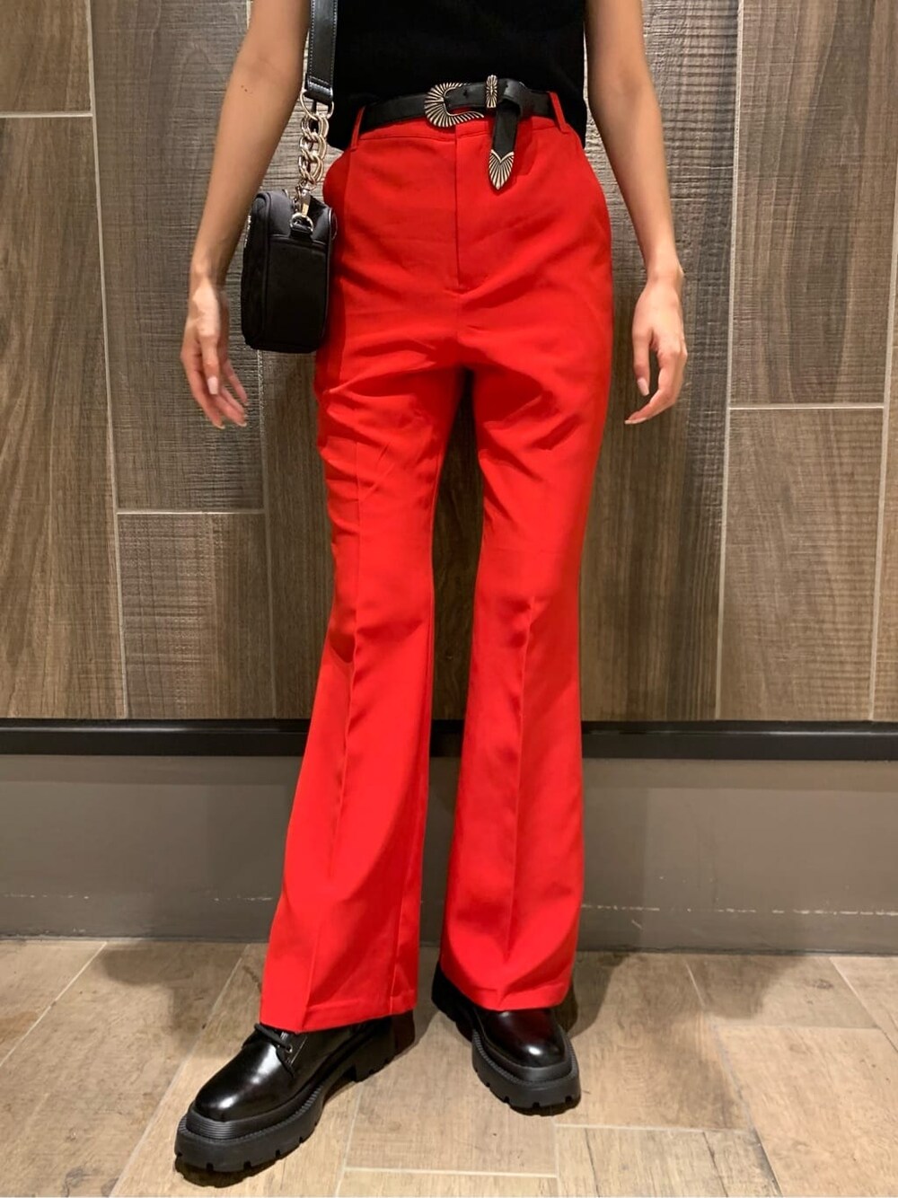 レッド系のその他パンツ、ブラック系のショルダーバッグ、ブラック系のブーツを着用したレディースの夏コーディネートの6枚目の写真