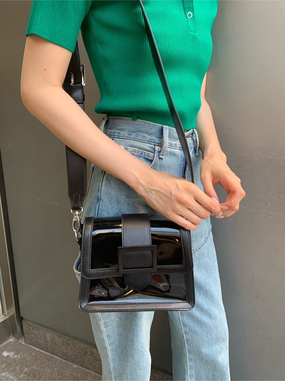 ブルー系のデニムパンツ、ブラック系のサンダル、ブラック系のショルダーバッグを着用したレディースの夏コーディネートの8枚目の写真