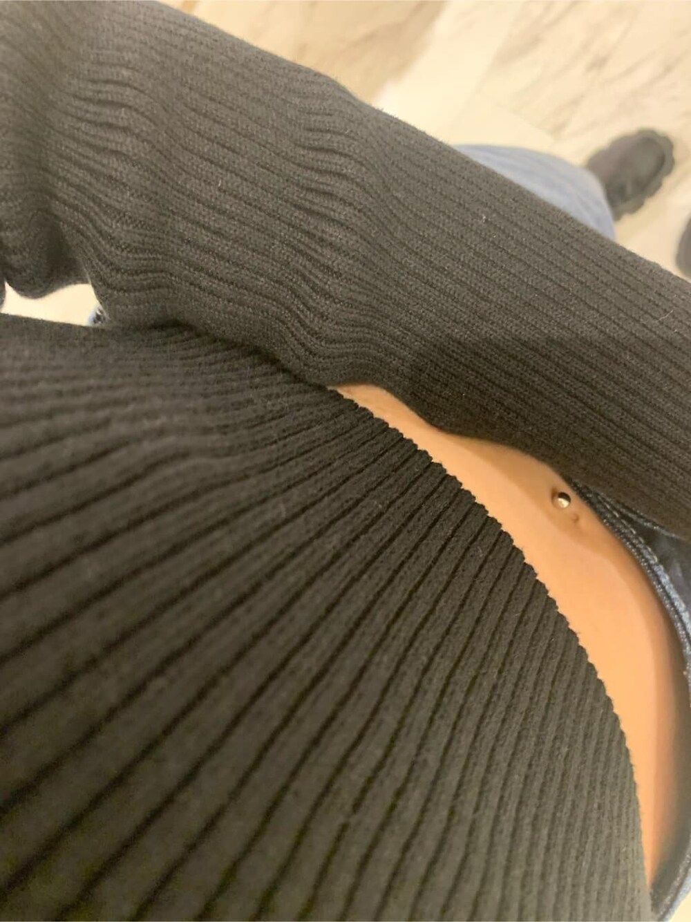 ブラック系のニット/セーター、ピンク系のハンドバッグ、ブルー系のデニムパンツを着用したレディースの秋コーディネートの3枚目の写真