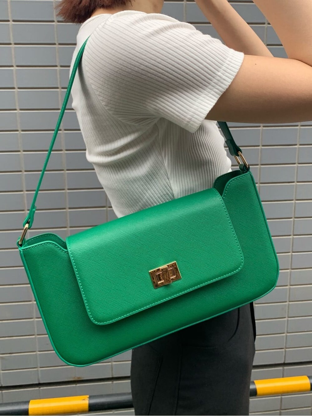 ブラック系のスカート、ブラック系のブーツ、グリーン系のショルダーバッグを着用したレディースの夏コーディネートの8枚目の写真