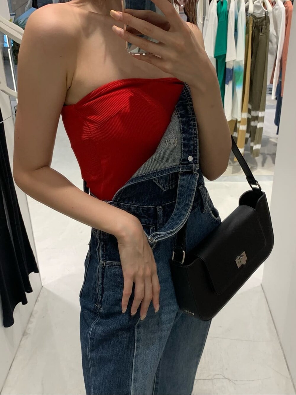 ブルー系のサロペット/オーバーオール、ブラック系のショルダーバッグ、ホワイト系のサンダルを着用したレディースの夏コーディネートの4枚目の写真