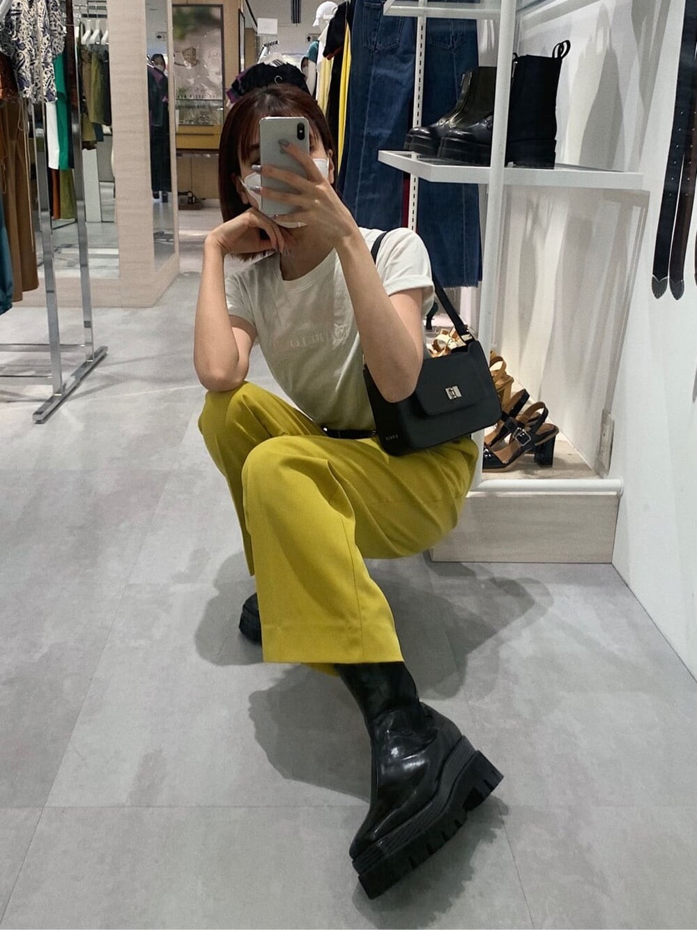 イエロー系のスラックス、ホワイト系のTシャツ/カットソー、ブラック系のブーツを着用したレディースの春コーディネートの10枚目の写真