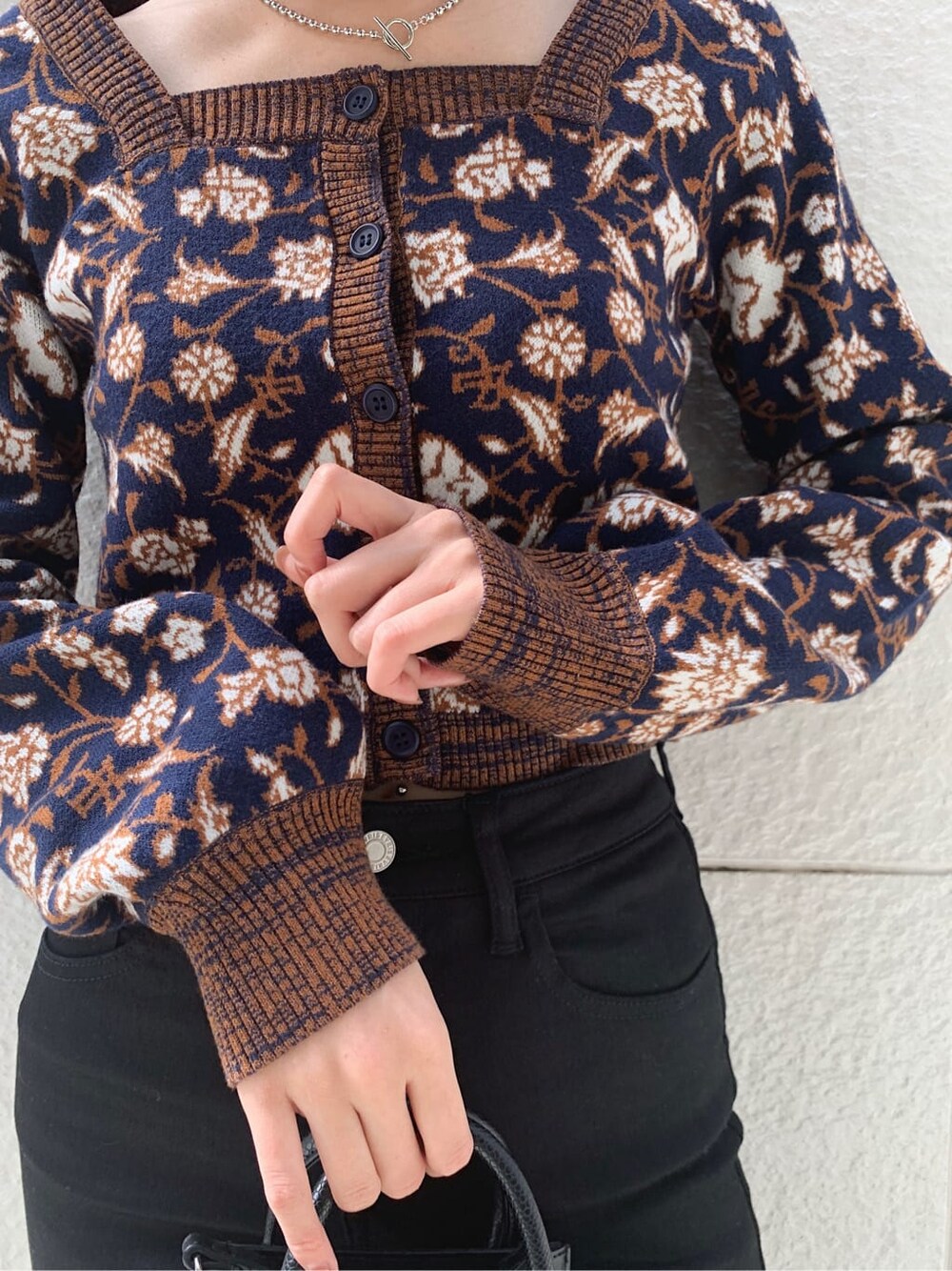 ブラック系のデニムパンツ、ブラック系のショルダーバッグ、ブラック系のブーツを着用したレディースの秋コーディネートの3枚目の写真