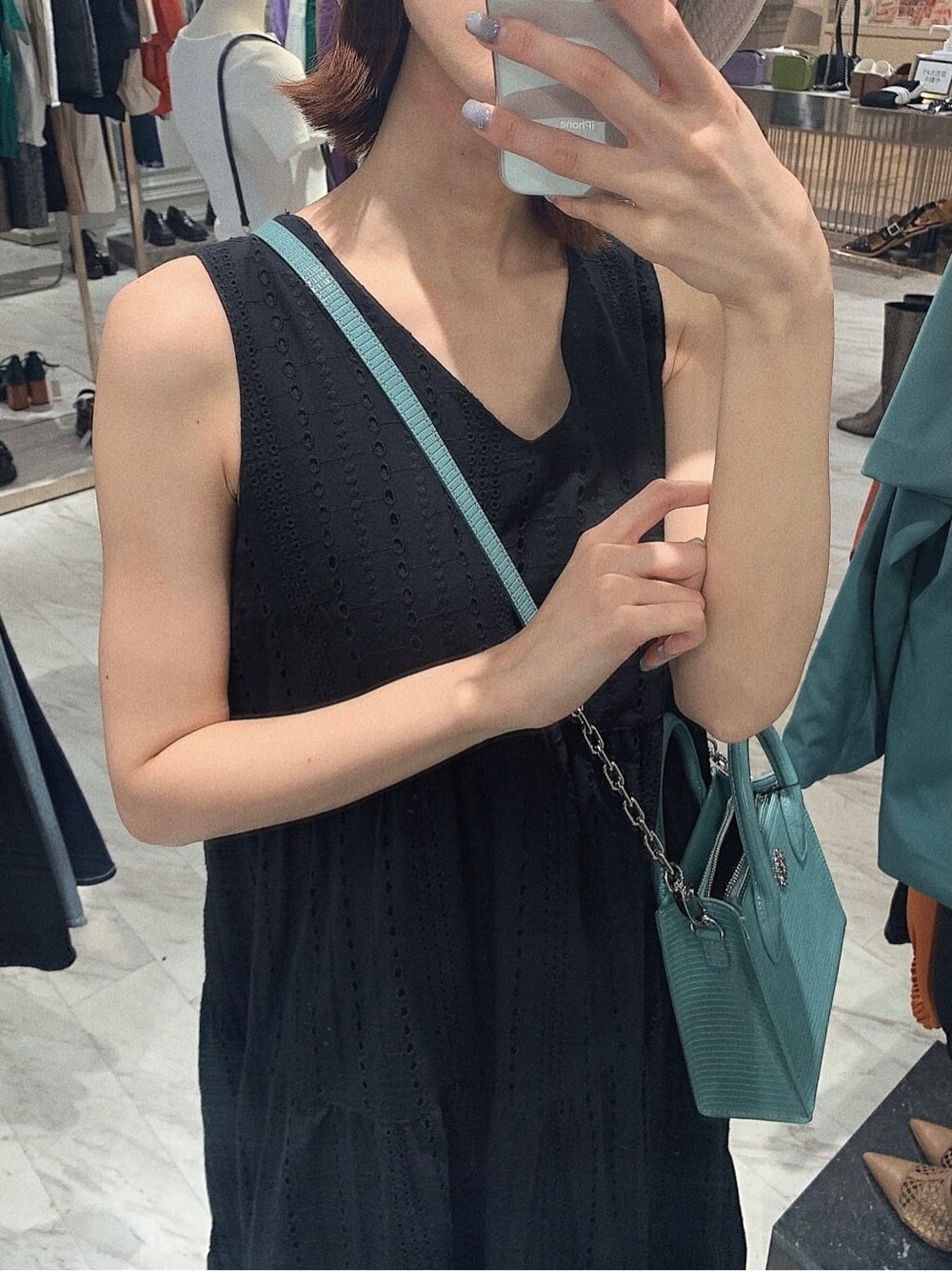 ブラック系のサンダル、ブラック系のワンピース、ブルー系のショルダーバッグを着用したレディースの春コーディネートの4枚目の写真