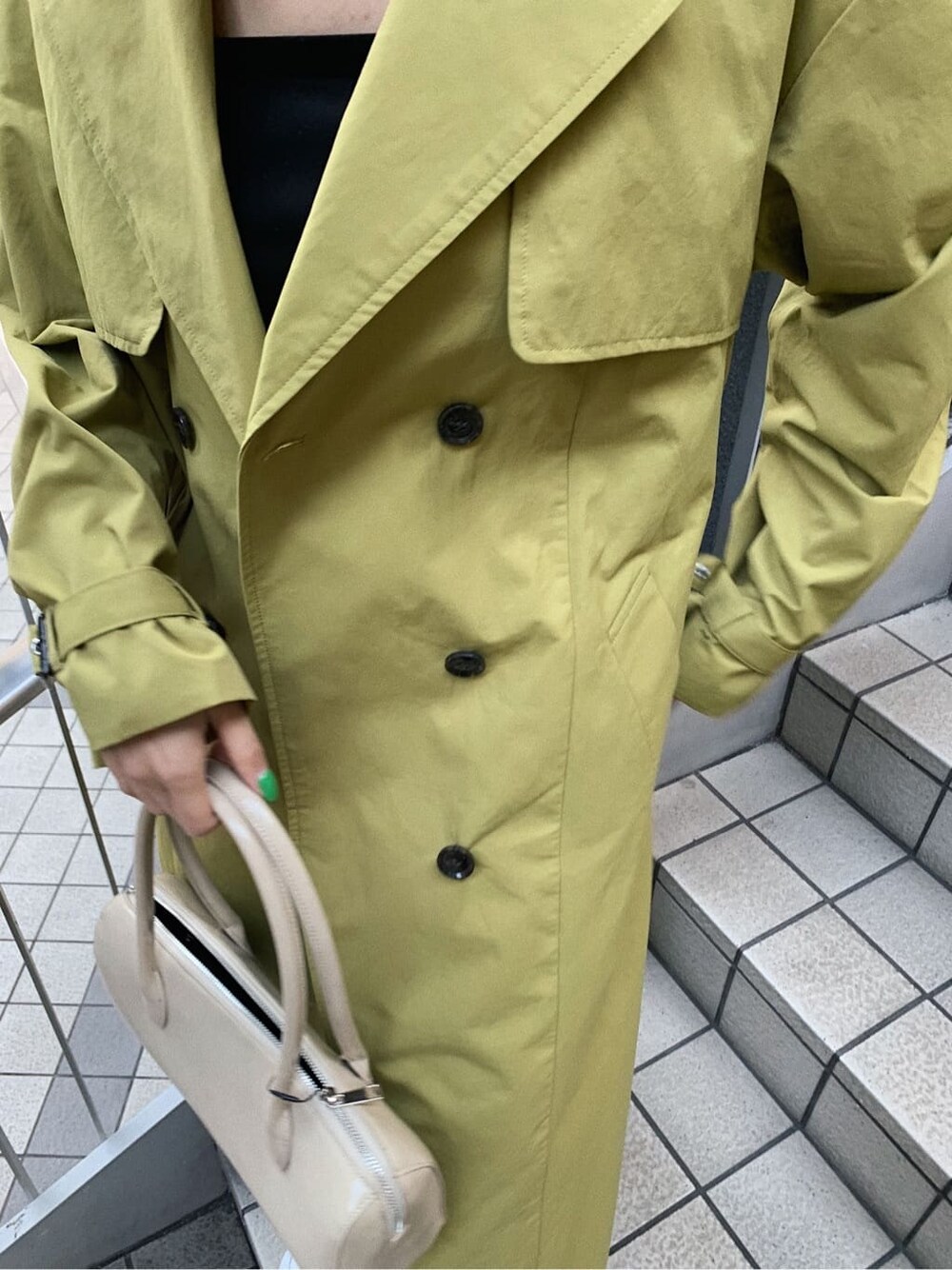 ブラック系のブーツ、ブラック系のデニムパンツ、ベージュ系のボストンバッグを着用したレディースの春コーディネートの4枚目の写真