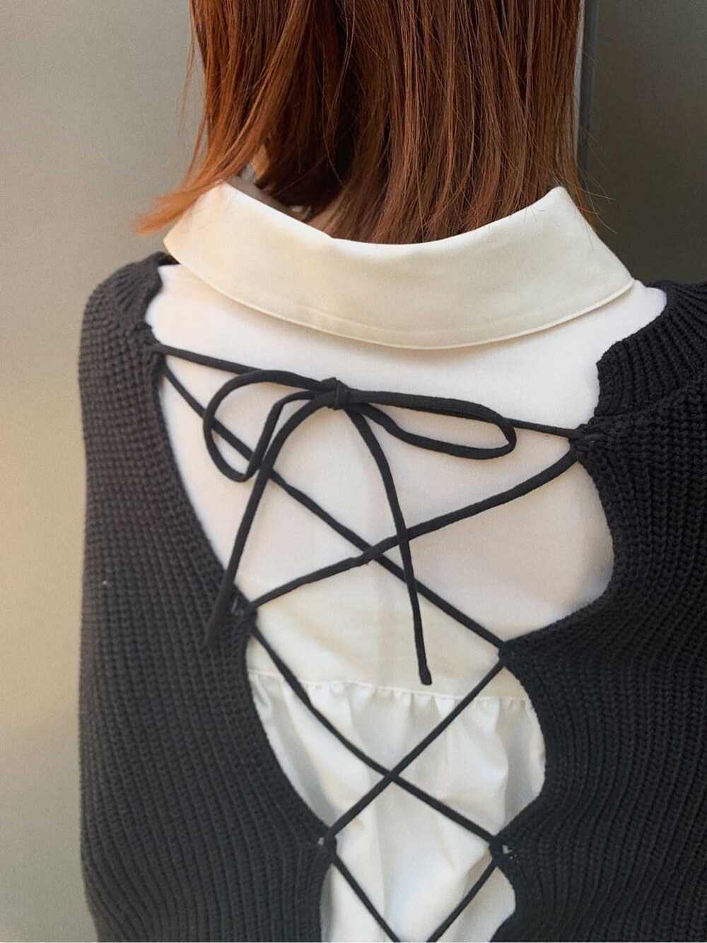 ブラック系のブーツ、ベージュ系のボストンバッグ、ホワイト系のシャツ/ブラウスを着用したレディースの冬コーディネートの6枚目の写真