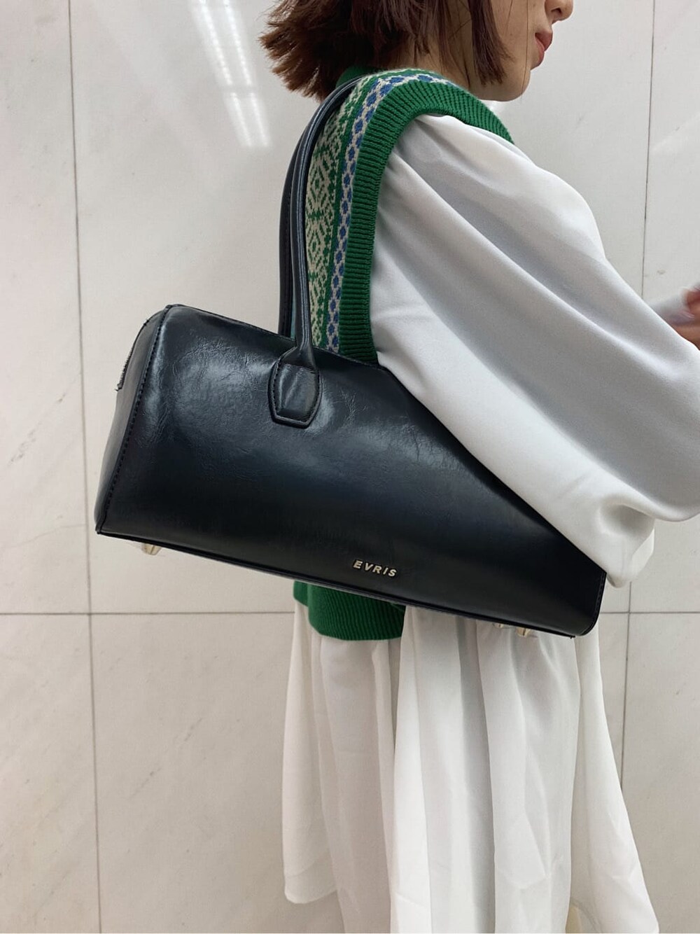 ブラック系のローファー、ブラック系のボストンバッグ、グリーン系のシャツ/ブラウスを着用したレディースの冬コーディネートの7枚目の写真