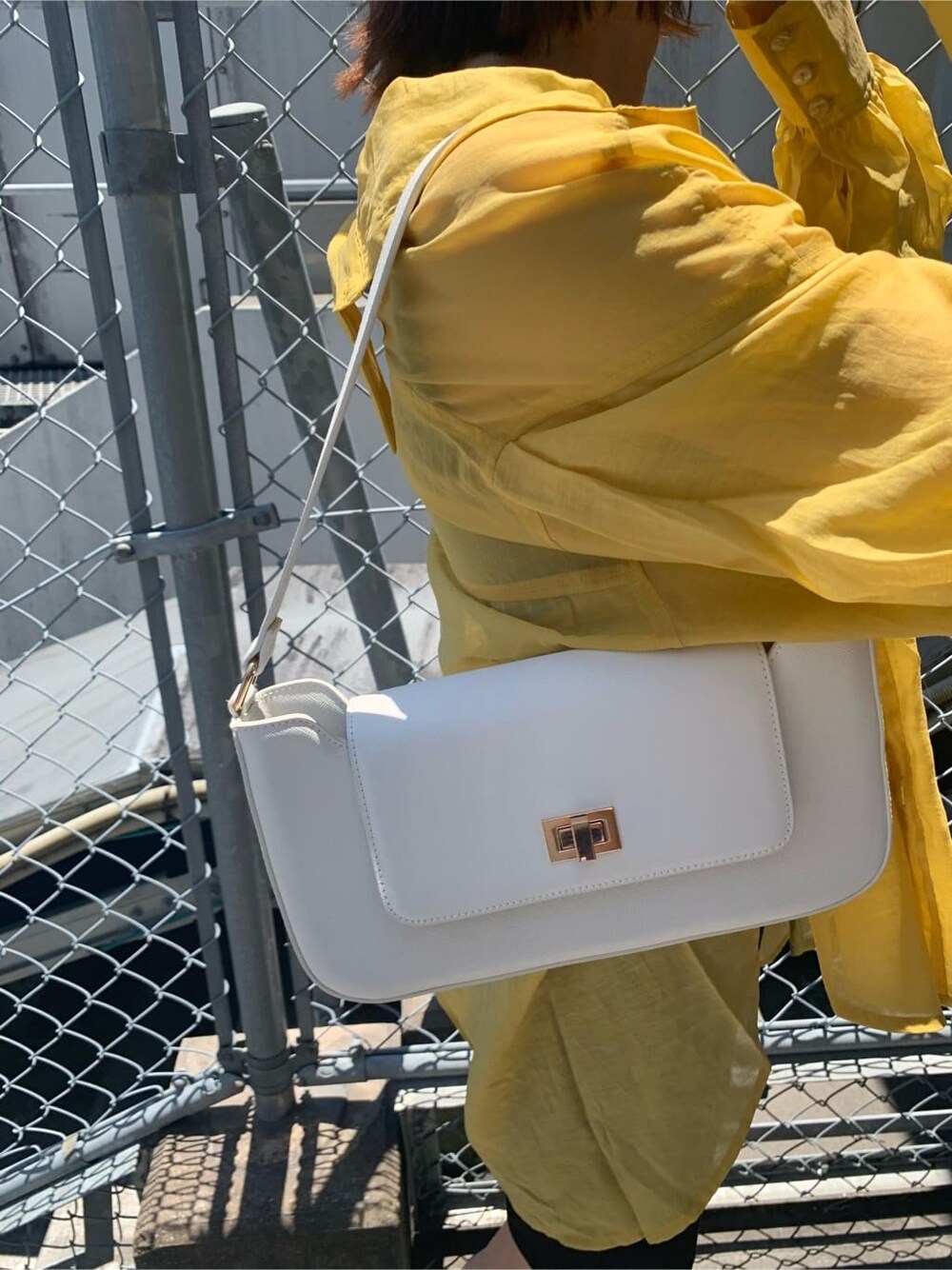 ブラック系のTシャツ/カットソー、ホワイト系のショルダーバッグ、ブラック系のその他パンツを着用したレディースの夏コーディネートの9枚目の写真