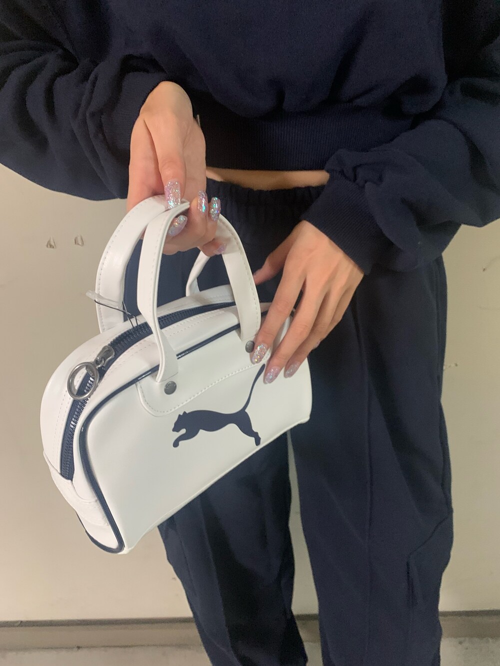 ブルー系のスウェット、ブルー系のスウェットパンツ、ホワイト系のハンドバッグを着用したレディースの秋コーディネートの7枚目の写真