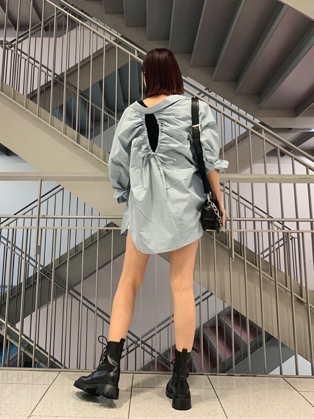 ホワイト系のデニムパンツ、ブルー系のシャツ/ブラウス、ブラック系のブーツを着用したレディースの夏コーディネートの2枚目の写真