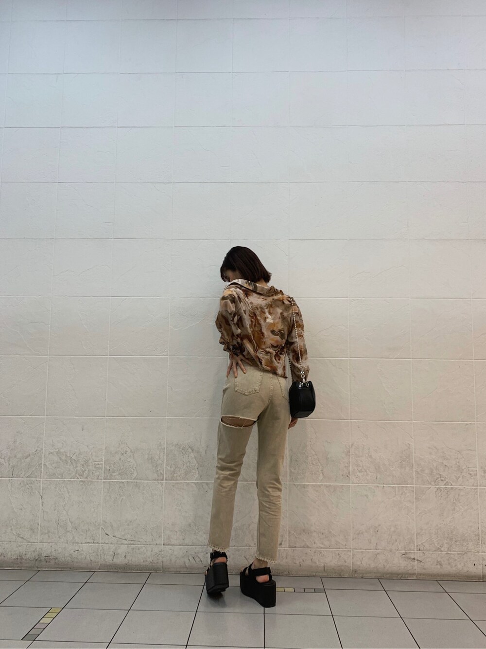 ブラウン系のキャミソール、ブラック系のサンダル、ベージュ系のデニムパンツを着用したレディースの春コーディネートの6枚目の写真