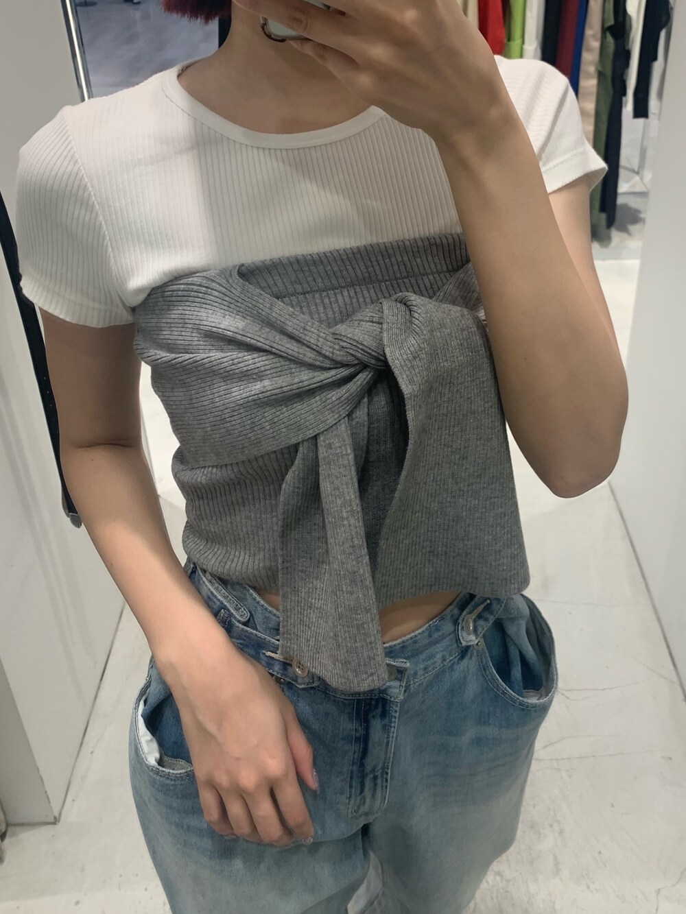 ブルー系のデニムパンツ、ブラック系のブーツ、グレー系のチューブトップを着用したレディースの春コーディネートの5枚目の写真