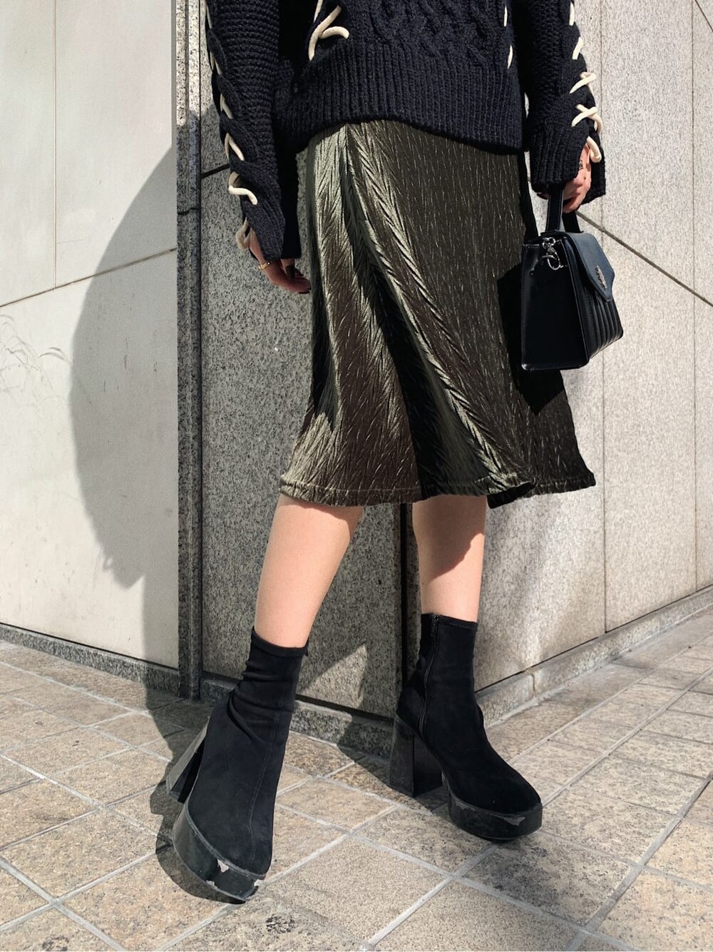 ブラック系のニット/セーター、ブラック系のショルダーバッグ、ベージュ系のワンピースを着用したレディースの冬コーディネートの5枚目の写真