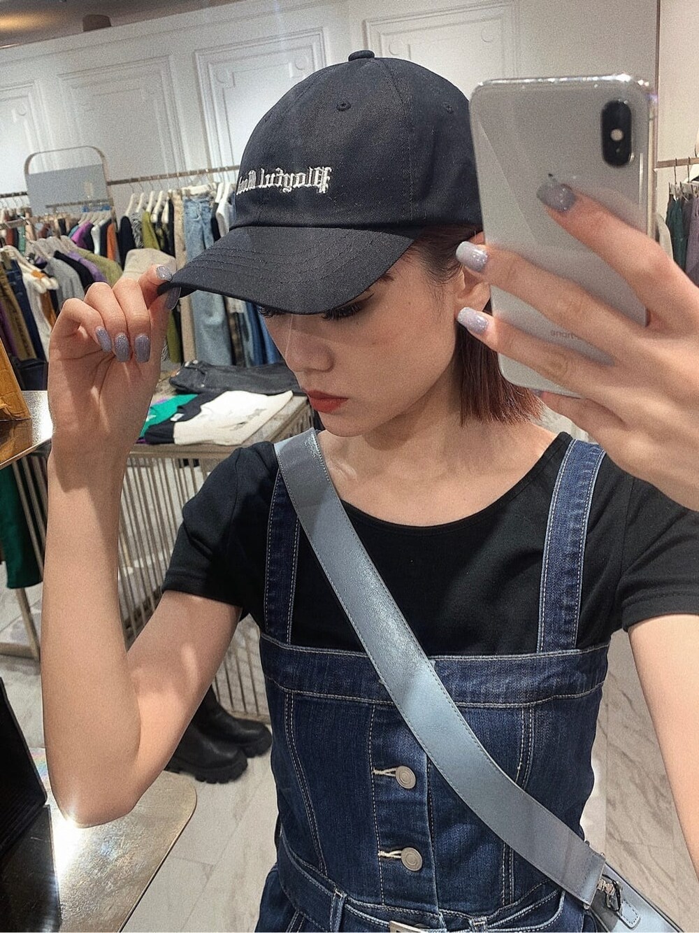 ブラック系のブーツ、ブラック系のTシャツ/カットソー、ブルー系のジャンパースカートを着用したレディースの春コーディネートの7枚目の写真