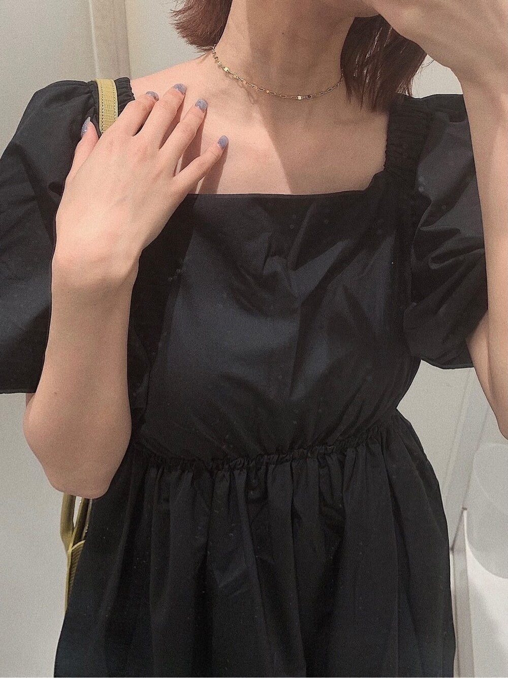 ブラック系のブーツ、イエロー系のショルダーバッグ、ブラック系のワンピースを着用したレディースの春コーディネートの9枚目の写真