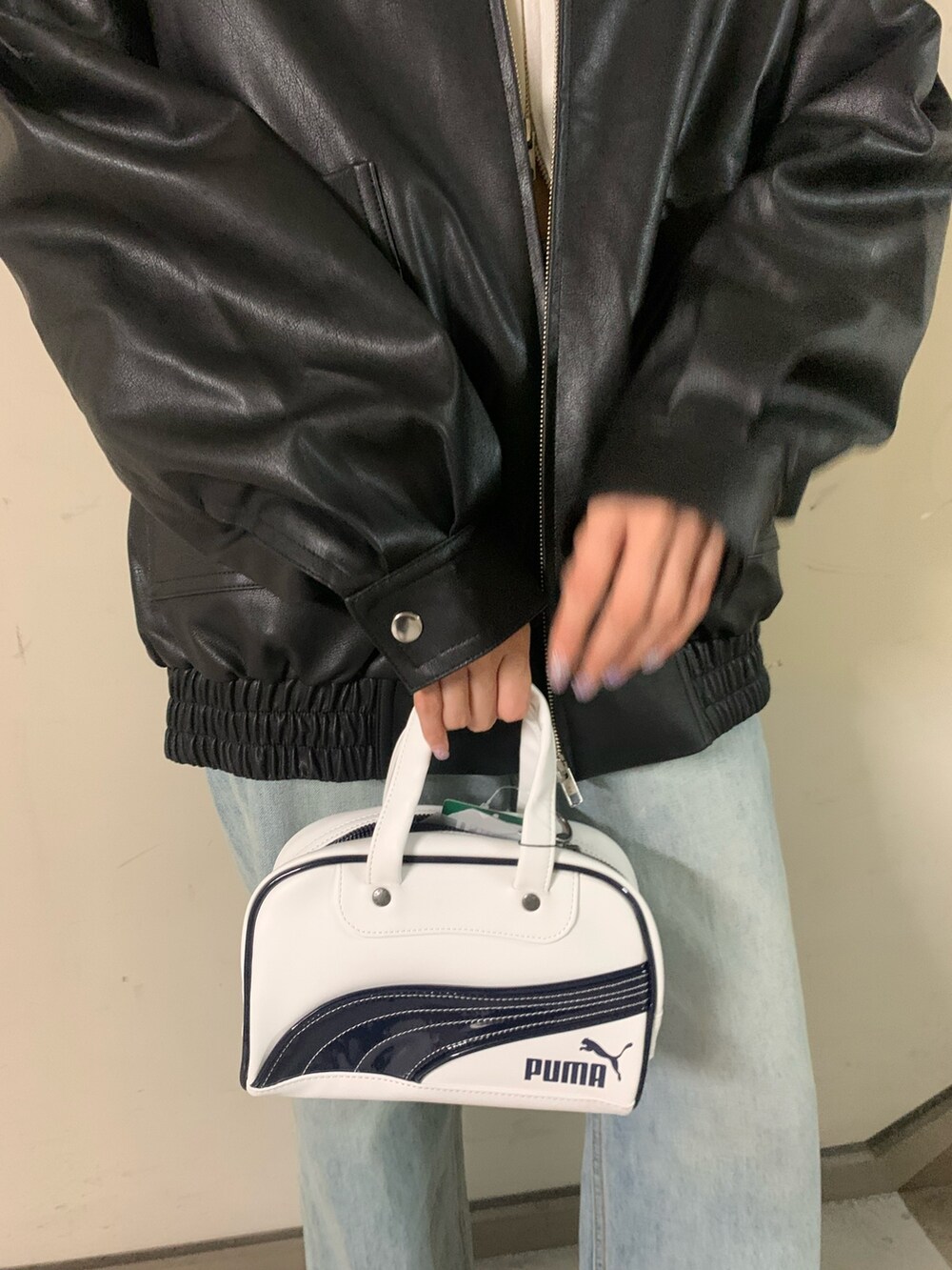 ホワイト系のニット/セーター、ブラック系のブルゾン、ブルー系のデニムパンツを着用したレディースの秋コーディネートの8枚目の写真